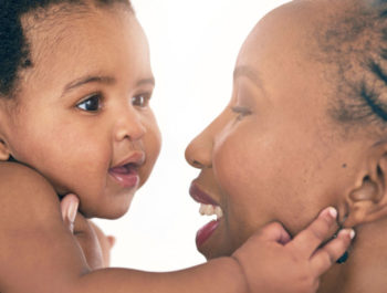 Mom holding a baby and smiling