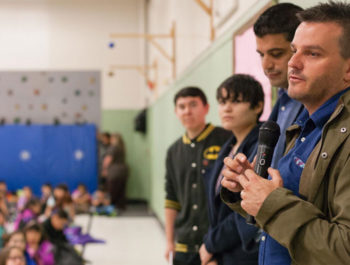 Refugees speaking to an auditorium of students