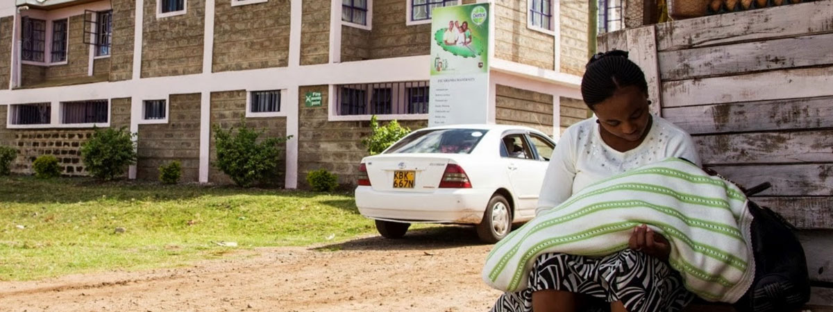 Woman sitting outside African hospital