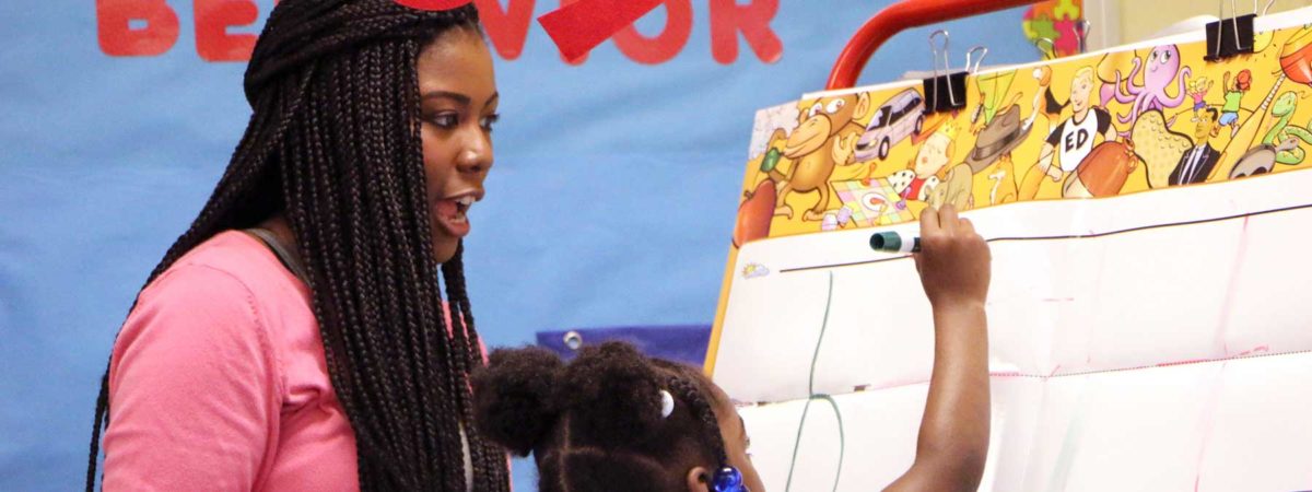 Woman teacher helping young girl