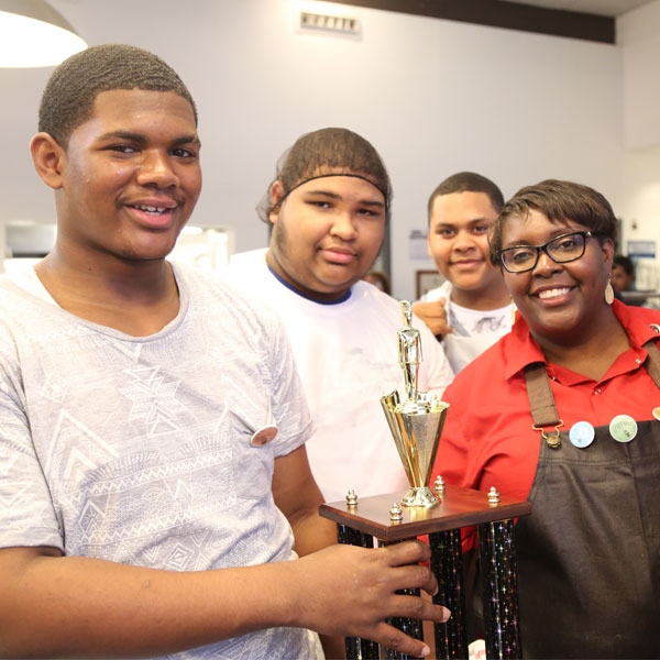 Four people holding a trophy