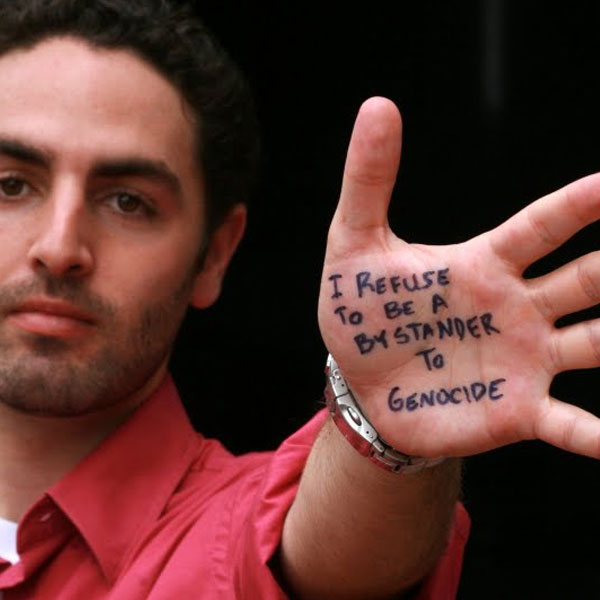 Mark Hannis showing his palm which reads I refuse to be a bystander to genocide