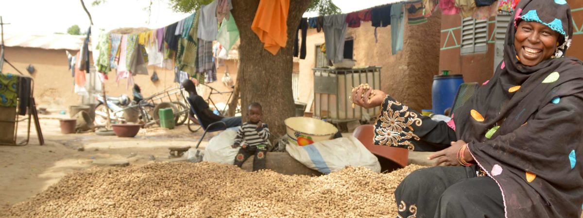 Woman farmer posing with her crop yield of peanuts