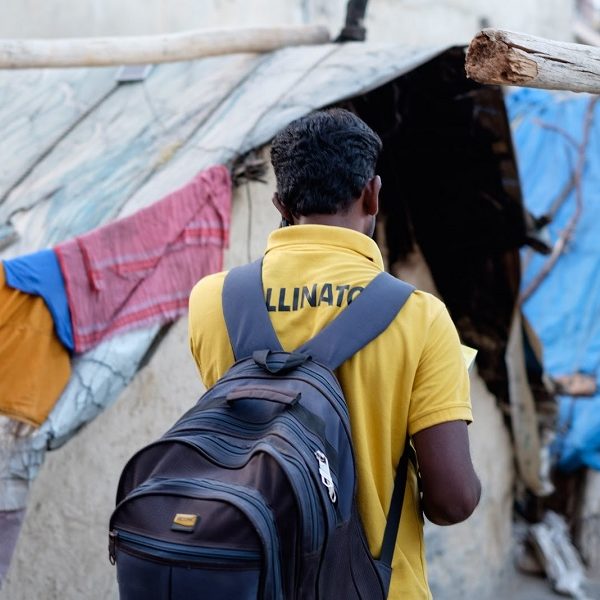 Pollinator walking thru streets of India in a yellow polo shirt