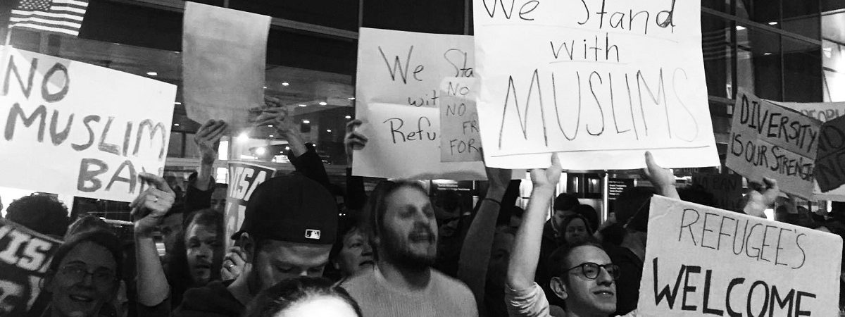Black and white photo of protesters holding signs reading