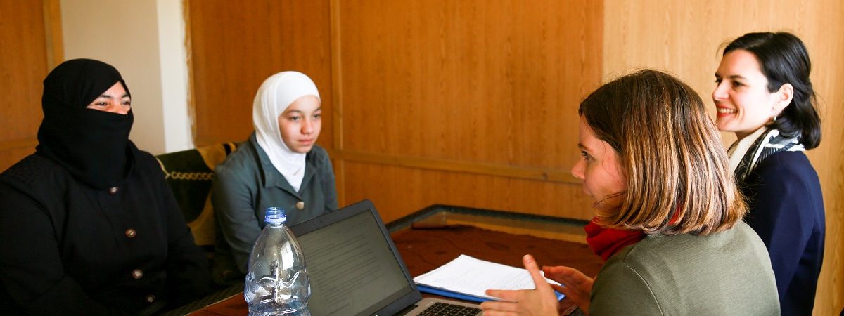 Two immigrant women speak with two women counselors in an office