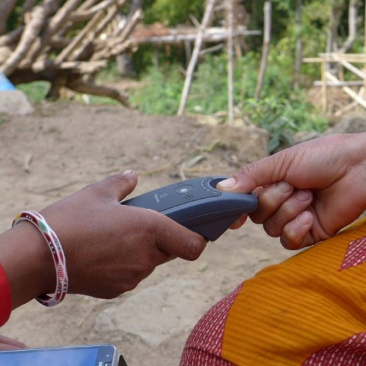 Finger being scanned in village
