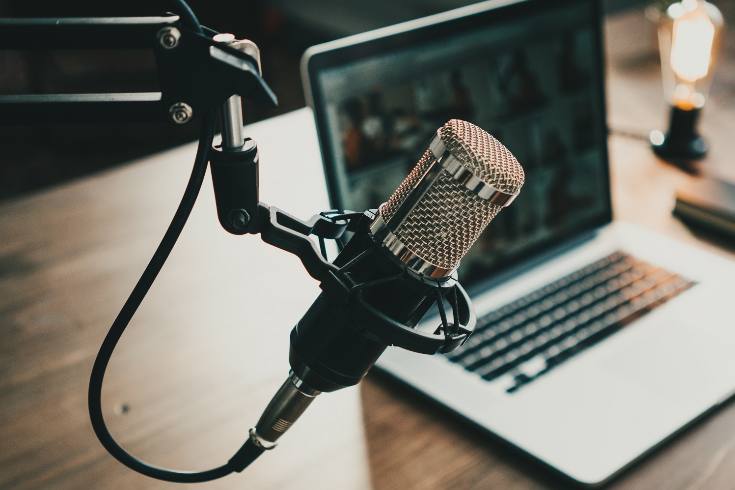 Home studio podcast interior. Microphone, laptop and on air lamp on the table, close-up