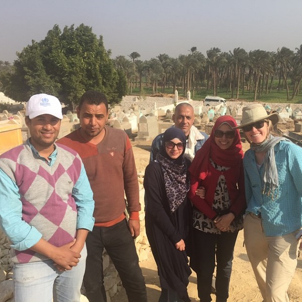 A group of six GlobalXplorers take time from digging to smile for a photo