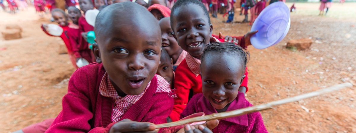 Happy African school children smile and play with utensils