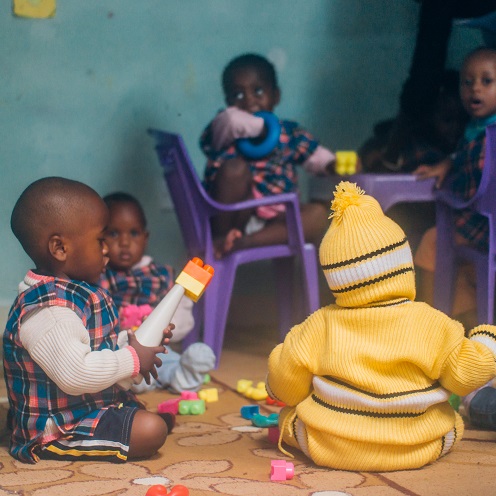 African children in daycare play on the floor with toys