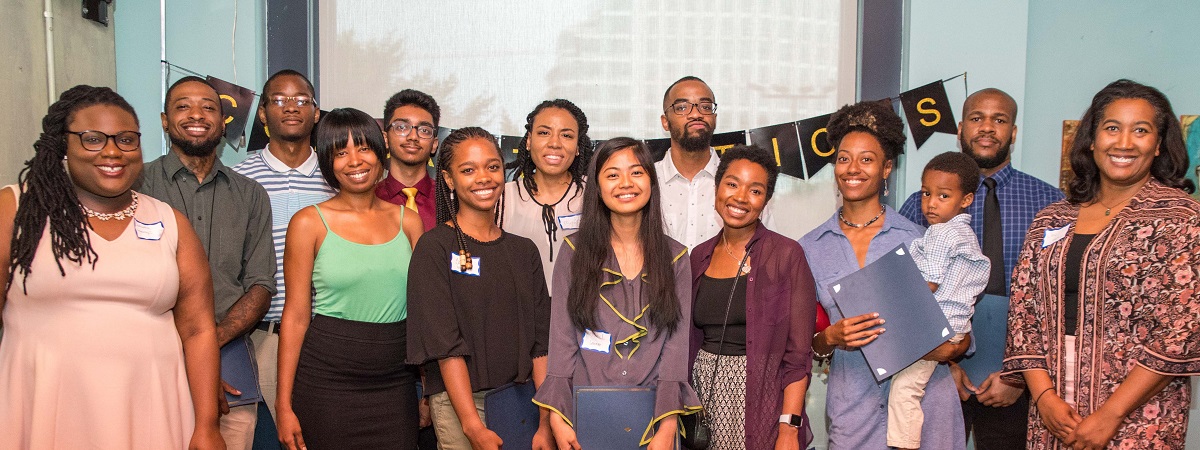 A large group of smiling African Americans gather at a Alpha Cohort Completion Event