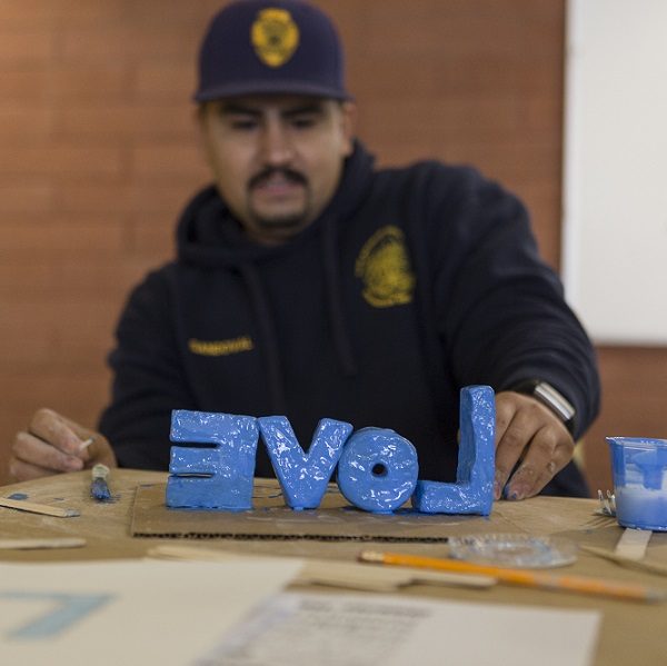 AIYN probation officer paints letters that spell out love in the color blue