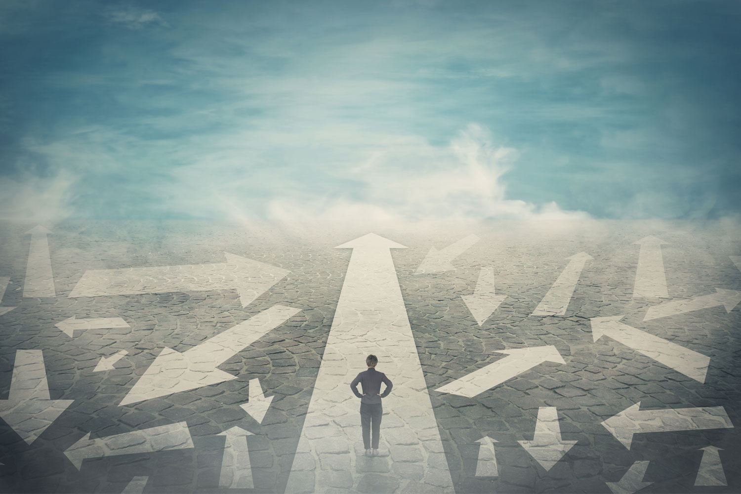 A person standing on a straight arrow road