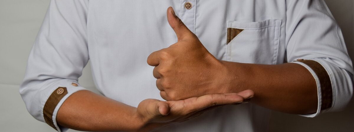 Close up Asian man shows hand gestures it means HELP isolated on white background. American sign language