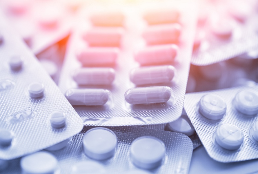 Different medicines: tablets, pills in blister pack, medications drugs, macro, selective focus, copy space, blue toned.