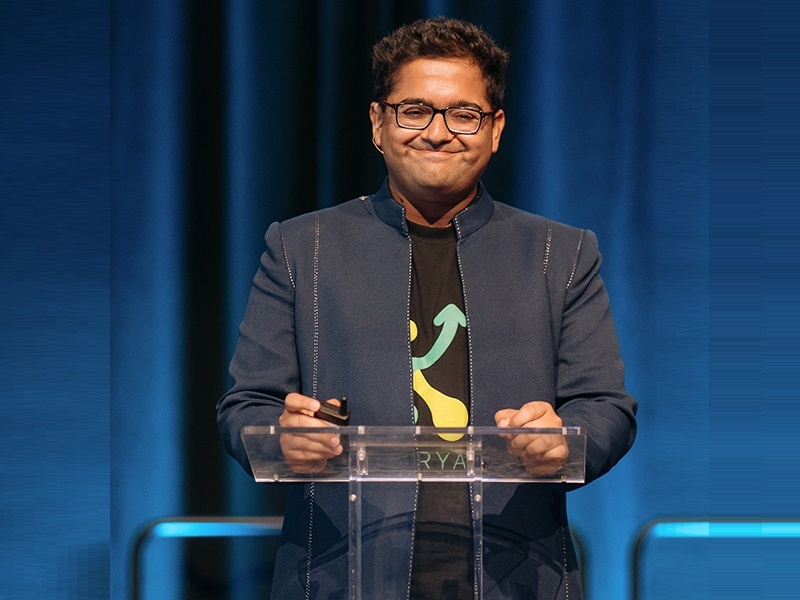 Manu Chopra stands at a podium