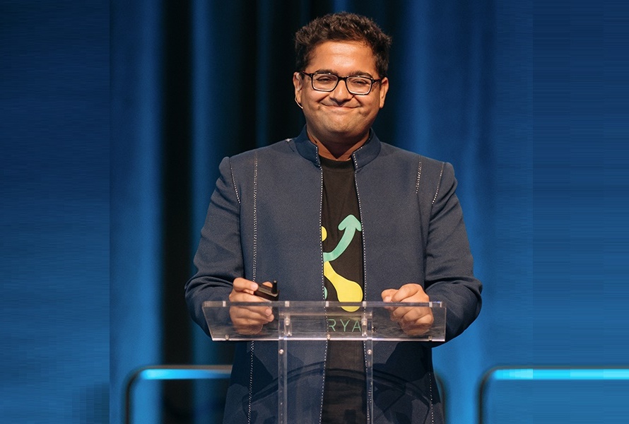 Manu Chopra stands at a podium