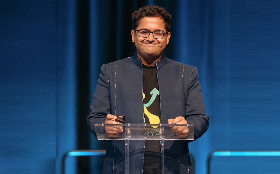 Manu Chopra stands at a podium