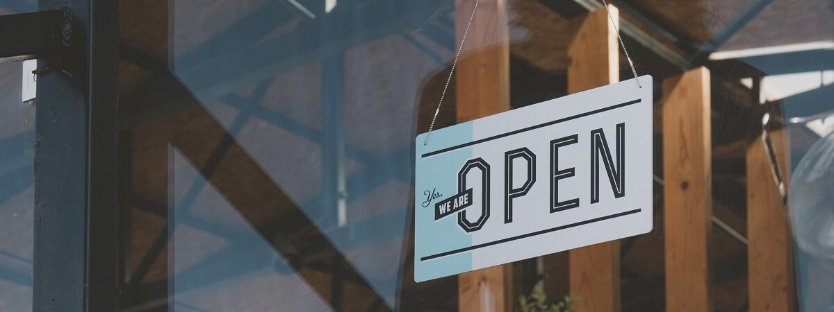 CU we are open sign hanging on the entrance door of a small cafe. Small business concept