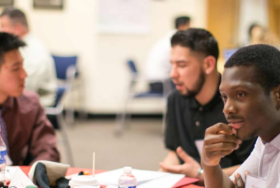 Young man listening attentively in a room full of people