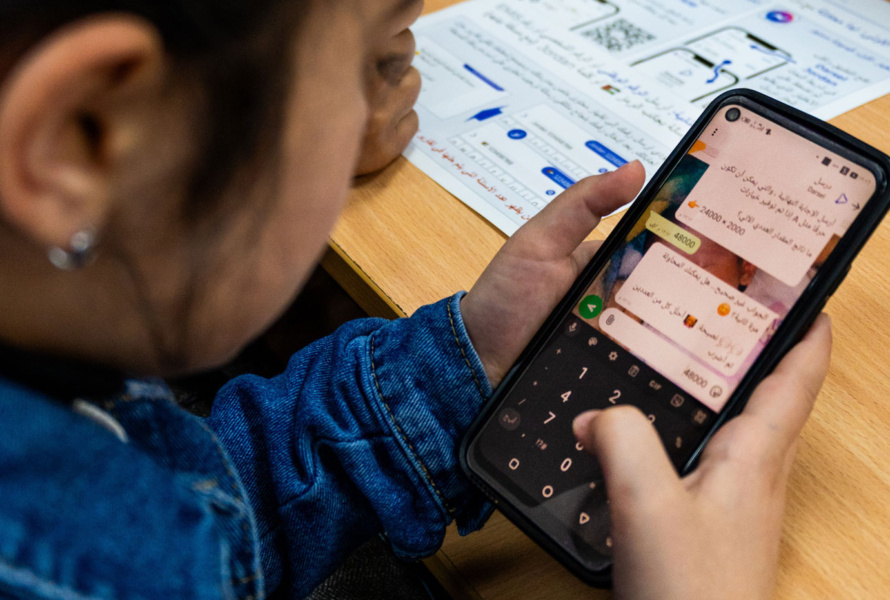 Child typing a number into a chat on a smartphone.
