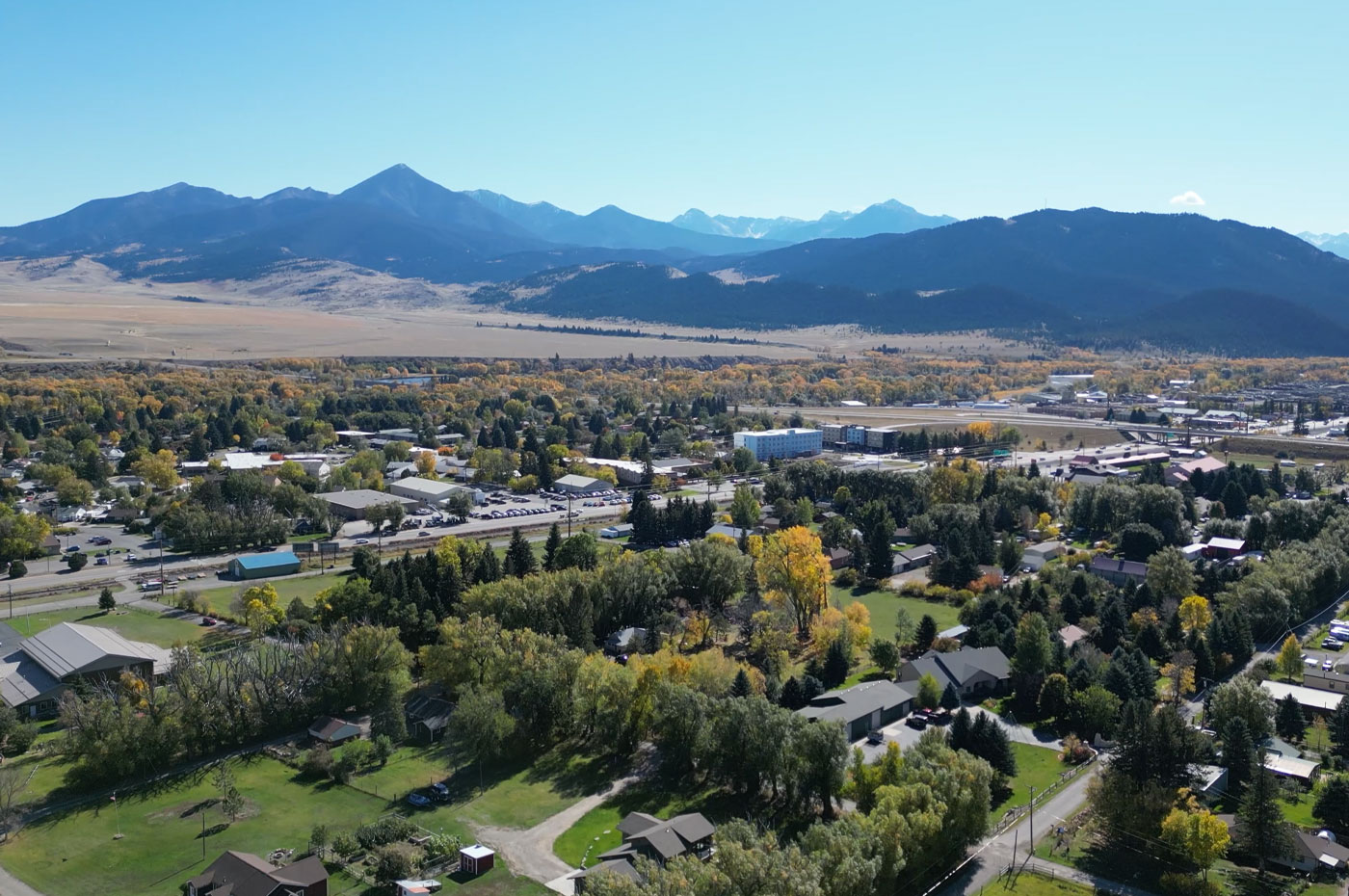 Bird's eye view of rural town with mountains in the background.