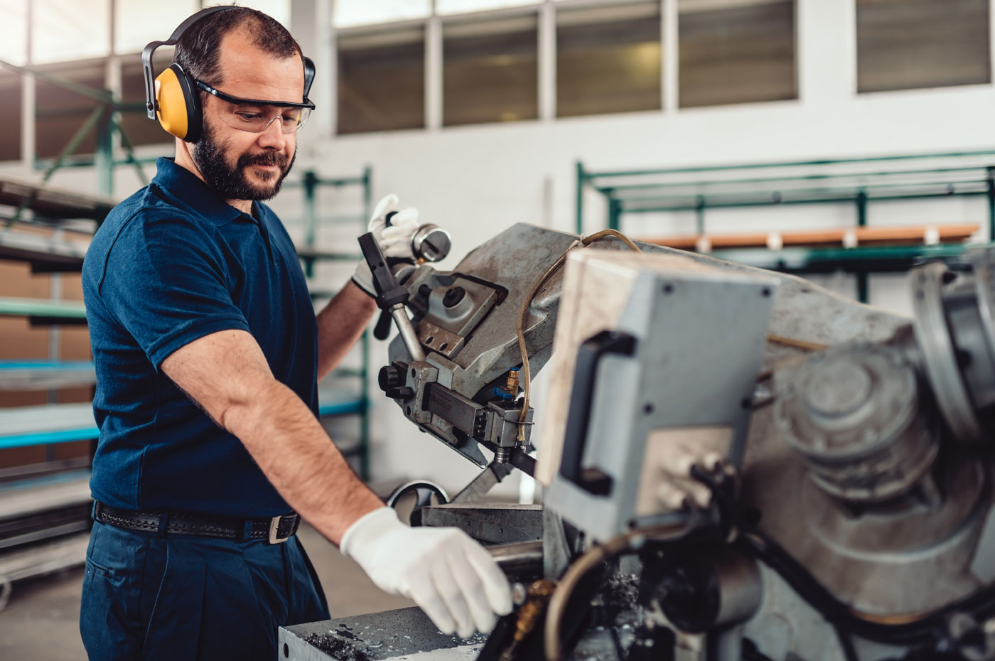 Man operating manufacturing equipment in a warehouse.