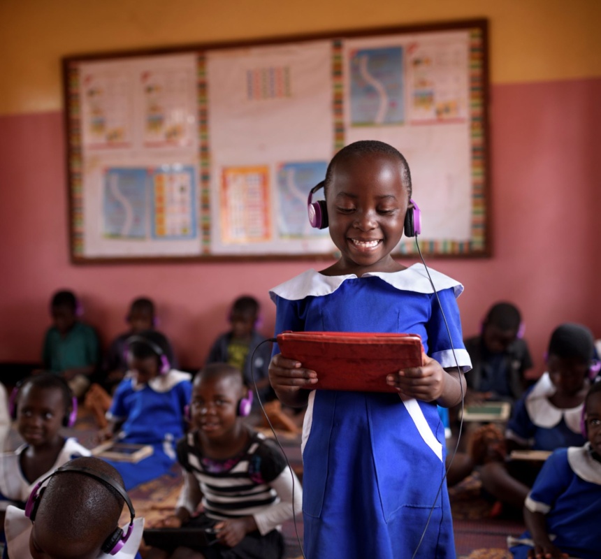 A African student smiles while looking at her learning device