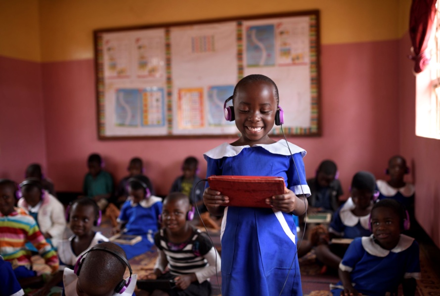 A African student smiles while looking at her learning device