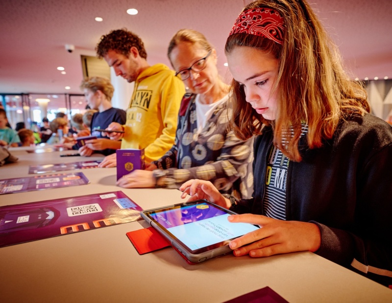 A young girl uses HackShield's game to learn about online safety while her mom watches.