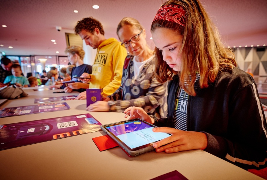 A young girl uses HackShield's game to learn about online safety while her mom watches.