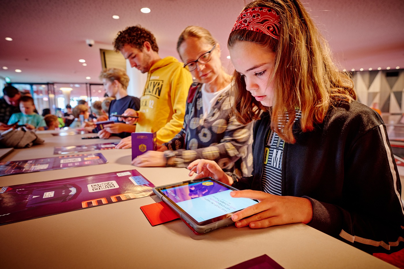 A young girl uses HackShield's game to learn about online safety while her mom watches.