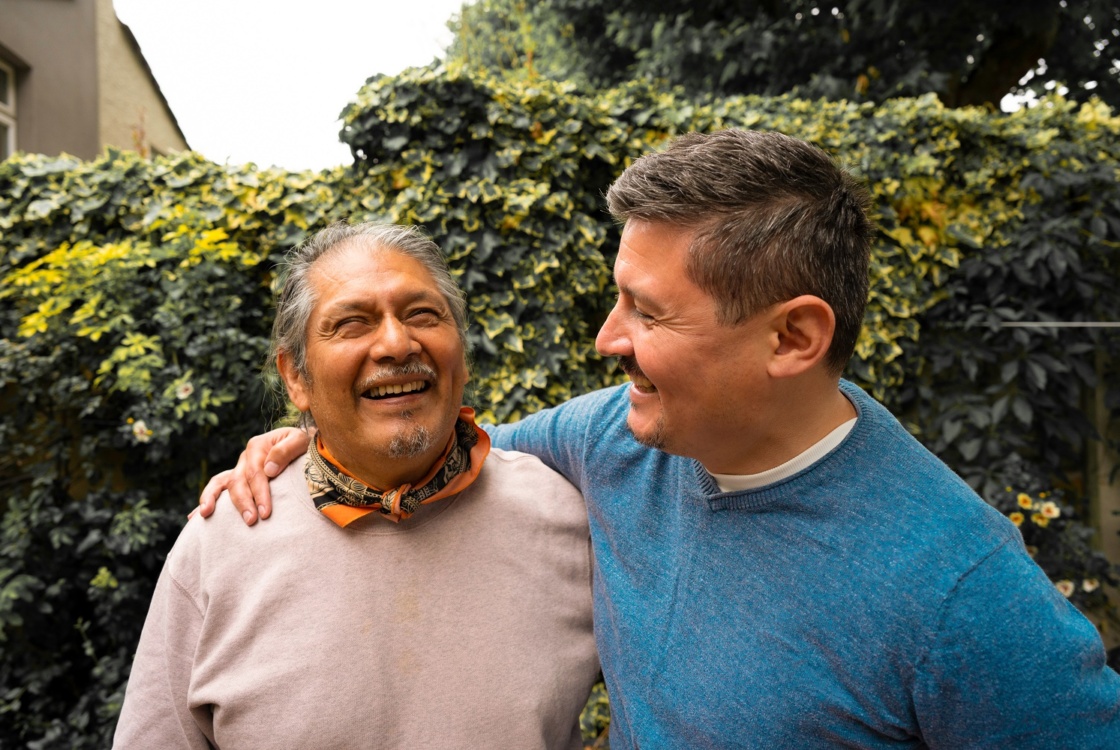 Smiling senior man with adult son outdoors