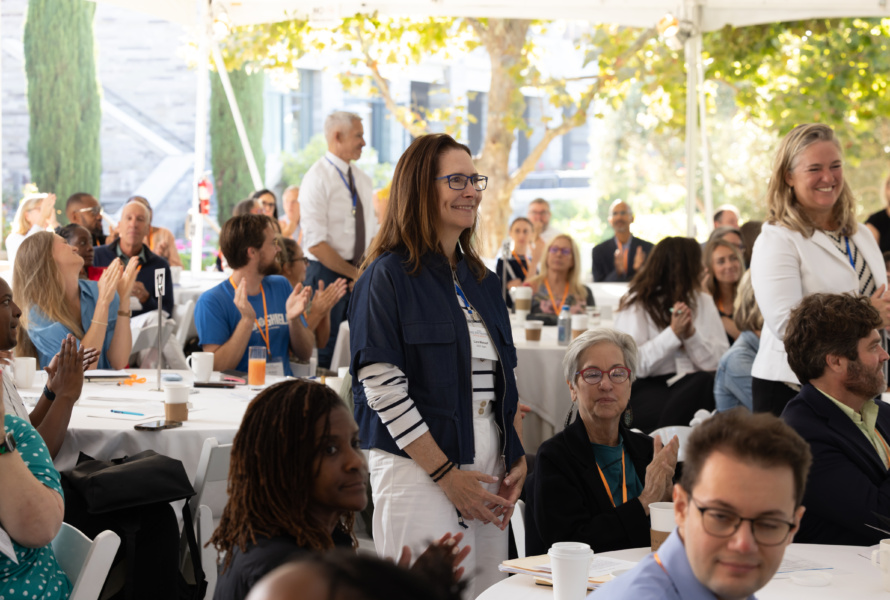 The DRK team stands up and is recognized for their work at a large gathering