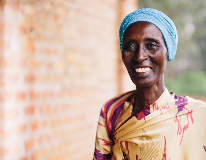 An African woman stands outside in traditional clothing