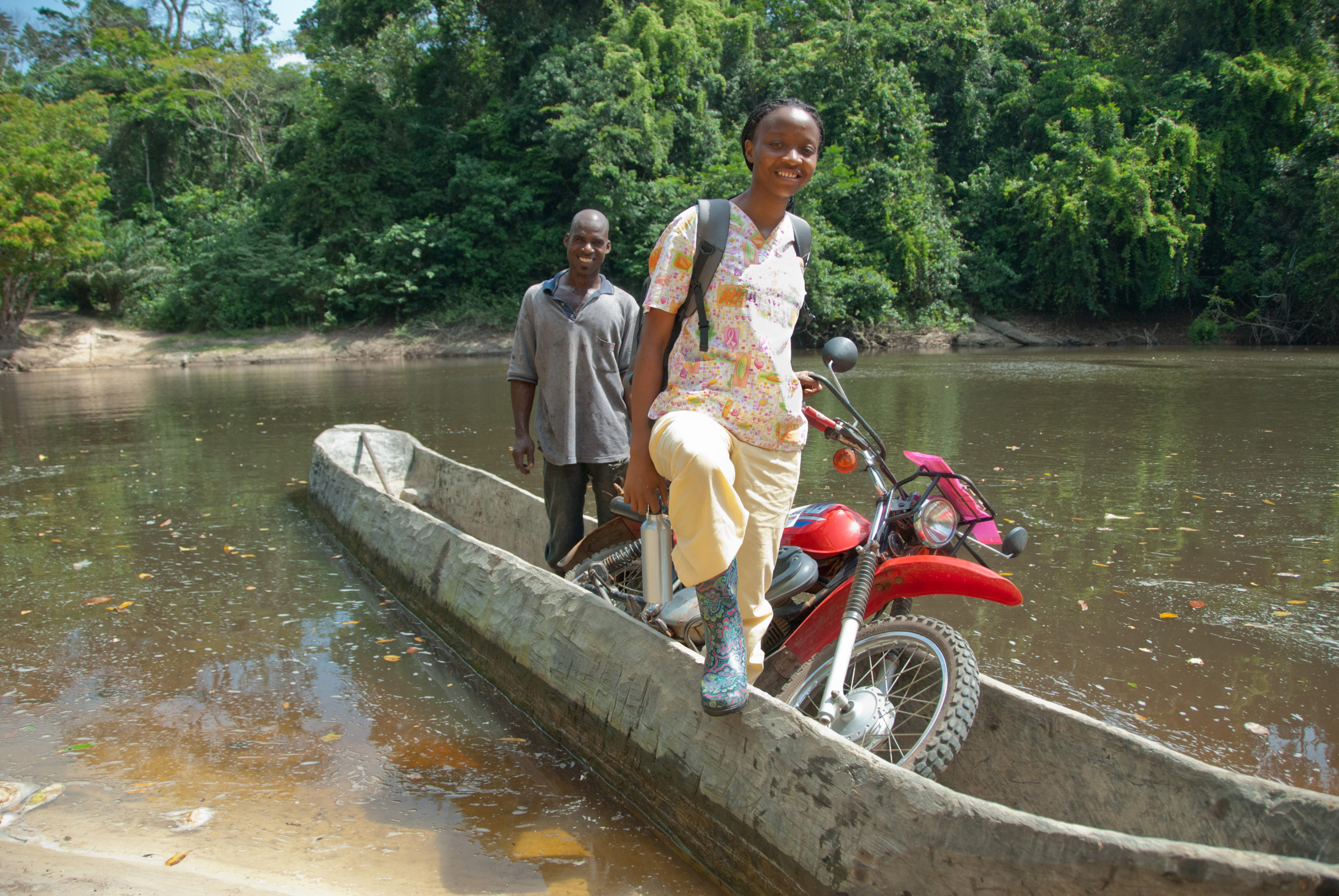 A health worker crosses a river in a canoe