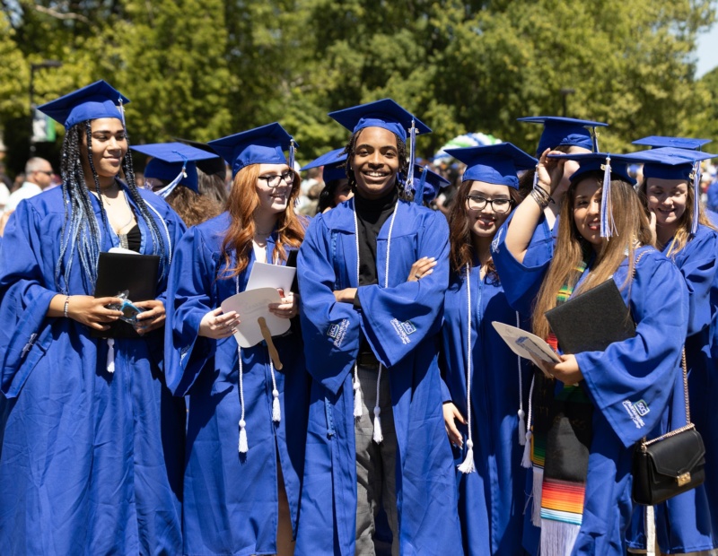 College graduates gather outside in their caps and gowns
