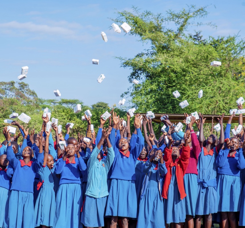 Young African children throw their medical supplies up in the air in a celebratory fashion