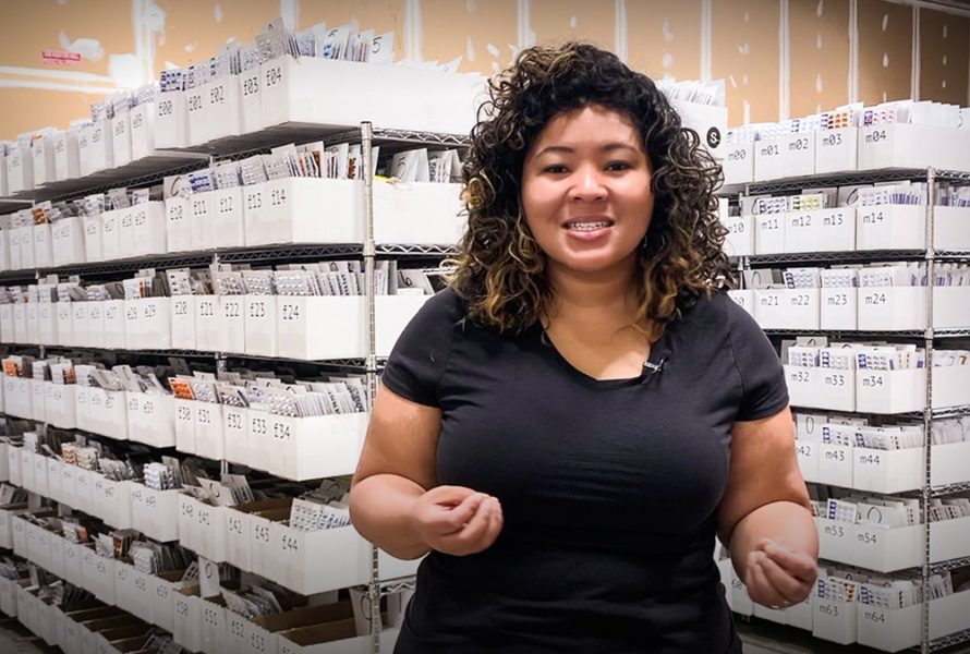 Kiah Williams of SIRUM stands in front of racks of medications