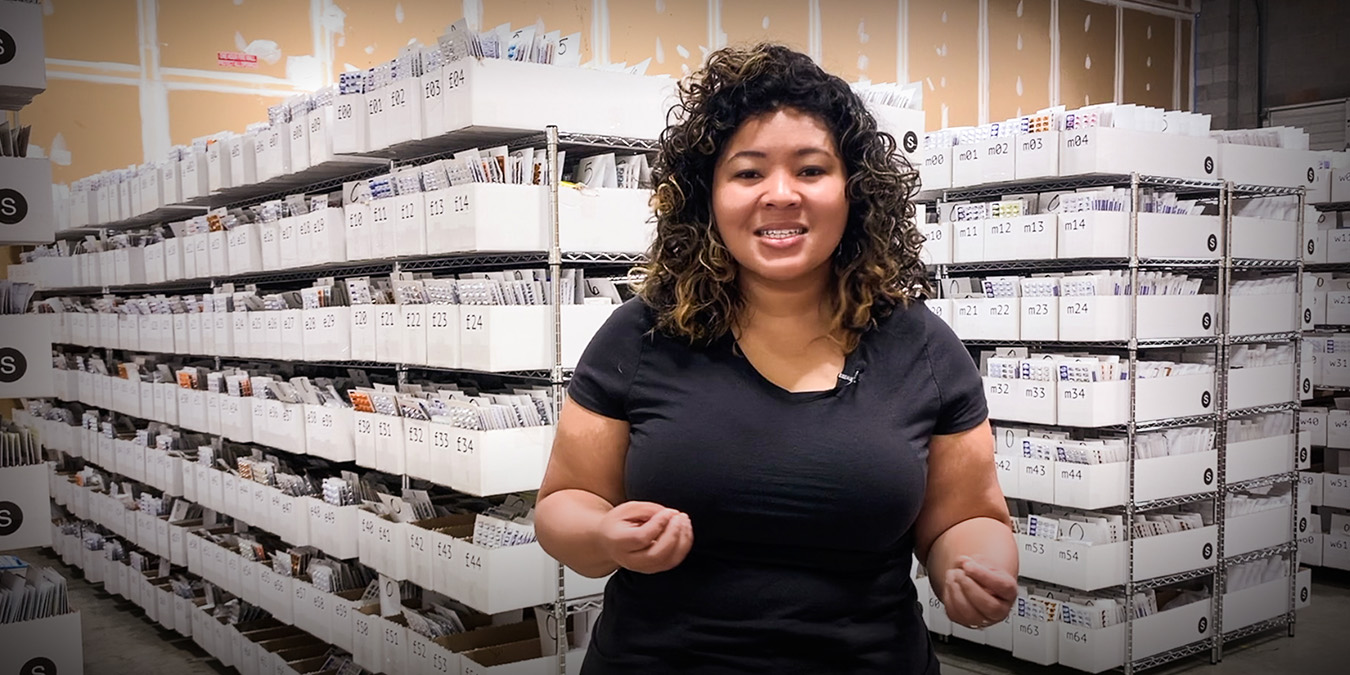 Kiah Williams of SIRUM stands in front of racks of medications