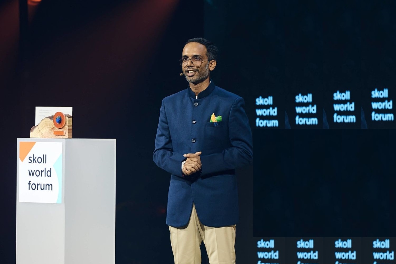 Tarun stands on stage to receiving Skoll World Forum award