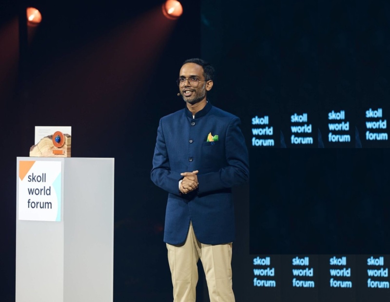 Tarun stands on stage to receiving Skoll World Forum award