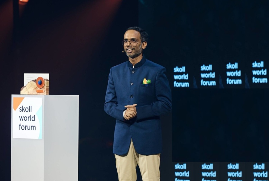 Tarun stands on stage to receiving Skoll World Forum award